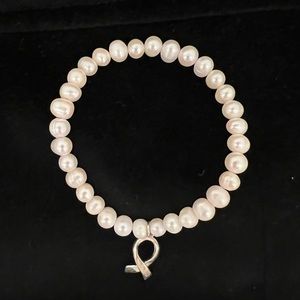 IVORY FAUX PEARL BRACELET WITH STERLING SILVER BREST CANCER AWARENESS CHARM.